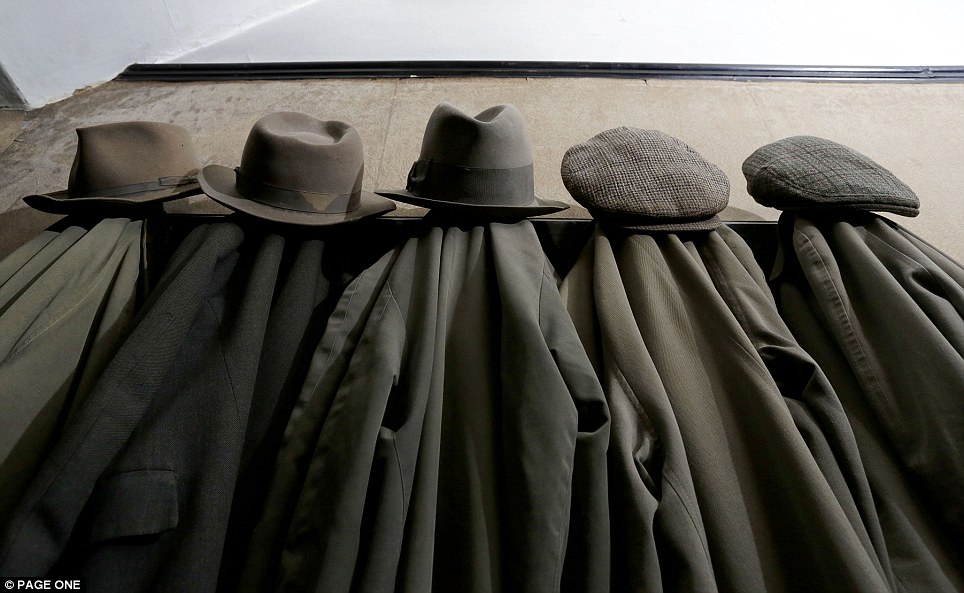 Untouched for decades: Mr Straw's flat caps and felt trilbies are hung above rows of identical raincoats in the hall of the solidly-constructed Midlands semi