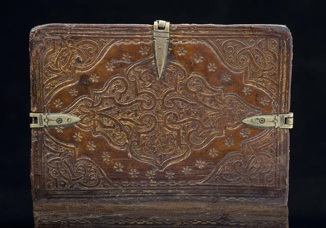 The intricately decorated leather cover.