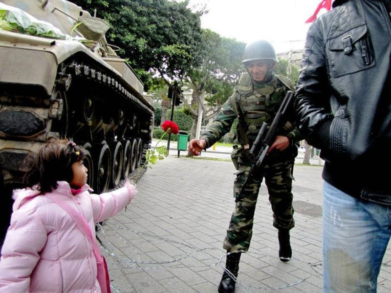 After the army refused orders to fire on innocent protesters, this little Tunisian girl handed one soldier a rose and told him that it would "defend the revolution." [Tunisian Revolution, 2011]