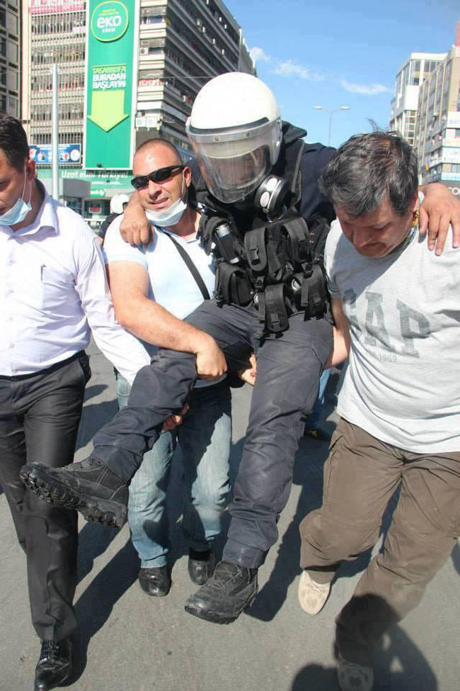 Protesters carry a wounded policeman to safety. [Turkey, 2013]