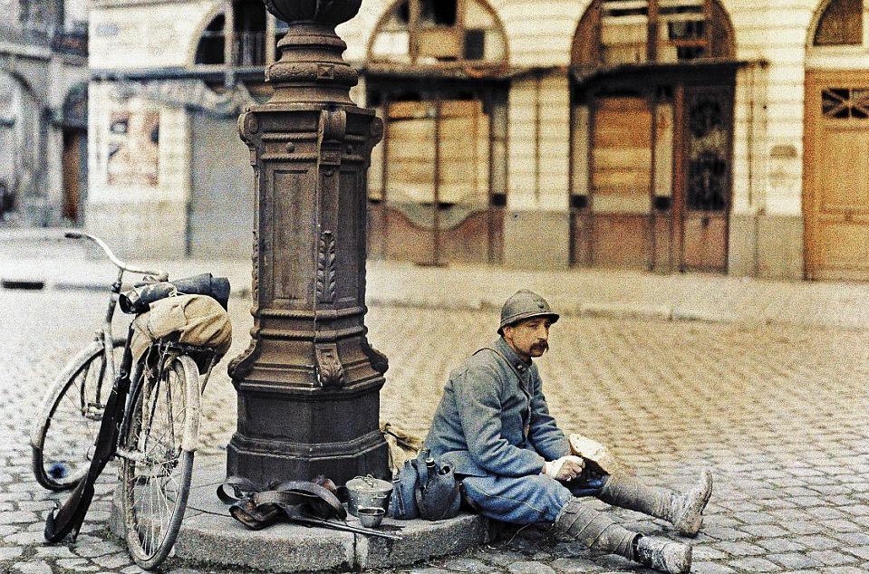 1st April, 1917 – a French soldier enjoys his lunch outside of an abandoned library in Reims, in north-eastern France: