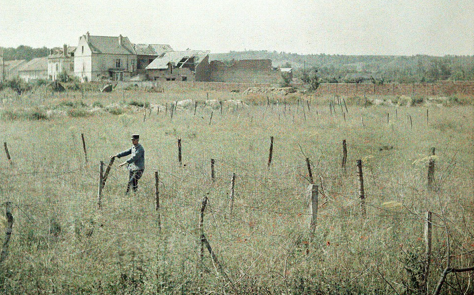 A French officer checking the damage to the barbed wire fences in Soissons: