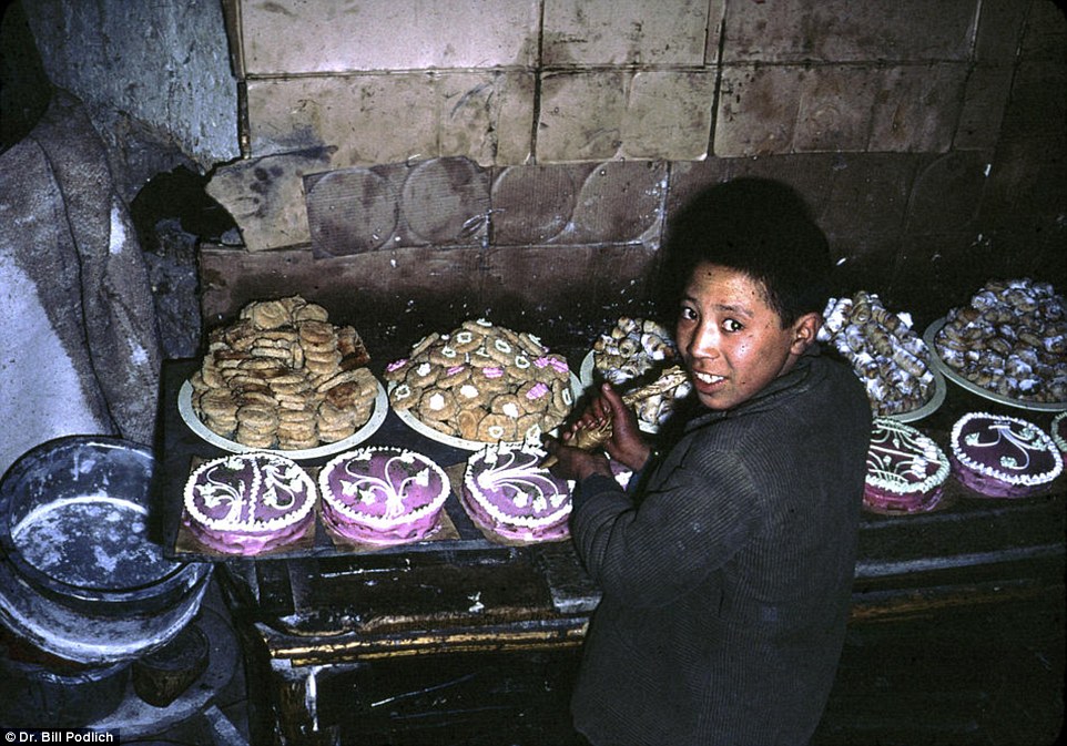 A happy Afghan boy decorating cakes.