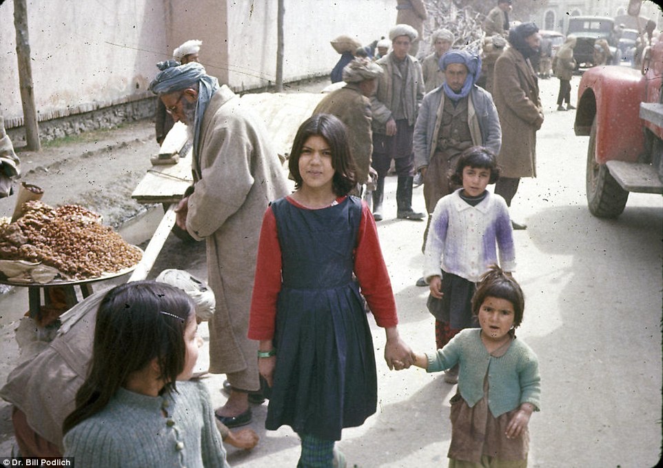 Two sisters hand in hand walking through Kabul