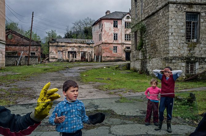 Children in the breakaway region of Abkhazia stop play to watch a car pass by