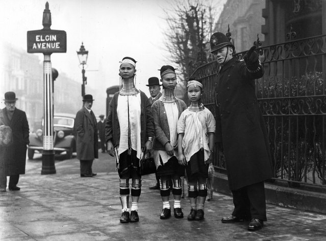 A policeman in London directing three giraffe necked women from Burma along Elgin Avenue, London, 1935