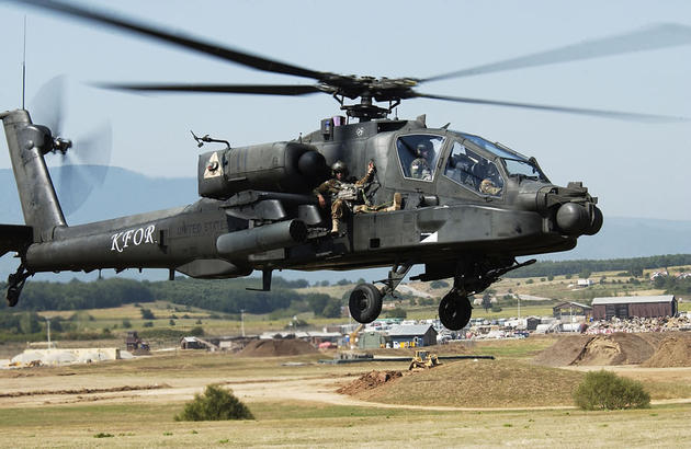 In the extreme case of a battlefield or natural disaster area rescue, the pilot or co-pilot of an AH-64 Apache will ride on the outside of the helicopter so the passengers can sit inside. At Camp Bondsteel, Kosovo, Aug. 25, Soldiers practice the tricky operation.