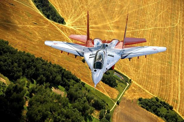 Russian Mig-29 flying over beautiful yellow fields.