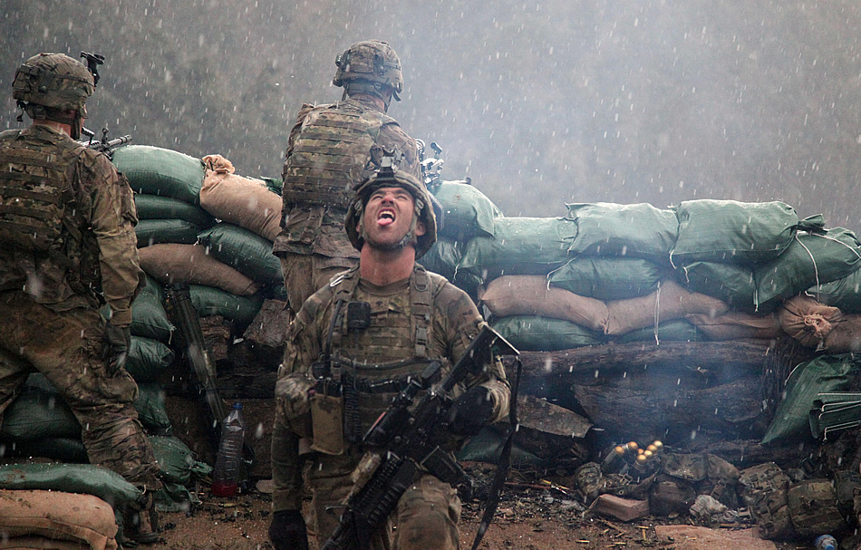 A U.S. Army soldier From the 2327th No Slack Battalion, 101st Airborne Division, relieved after a fire fight with the Taliban opens his mouth up towards the sky to taste the snow as it falls in the valley of Barawala Kalet, Kunar province, Afghanistan March 29, 2011.