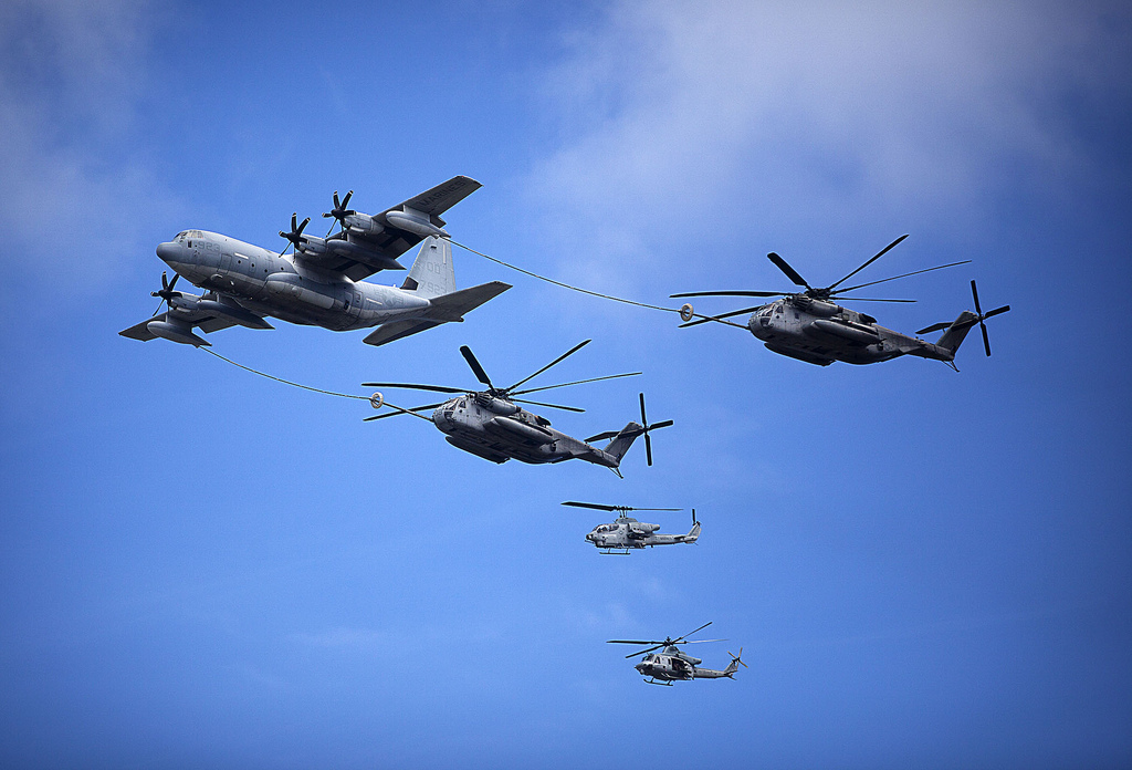A U.S. Marine Corps C-130 refuels two CH-53E Super Stallion helicopters under the watch of an AH-1 Cobra and a modernized UH-1Y Venom during the 2012 Kaneohe Bay Air Show on Marine Corps Air Station, Kaneohe Bay, Hawaii, Sept. 28, 2012.
