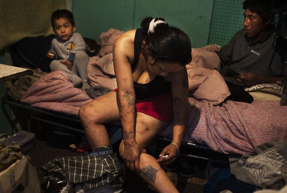A mother injects heroin in front of her child and lover
