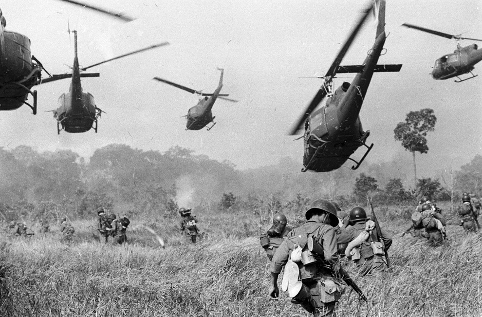 Hovering U.S. Army helicopters pour machine gun fire into the tree line to cover the advance of South Vietnamese ground troops in an attack on a Viet Cong camp 18 miles north of Tay Ninh, Vietnam, northwest of Saigon near the Cambodian border. March 1965