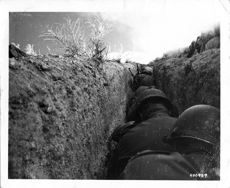 American soldiers shelter in a trench just over a mile from ground zero moments after the detonation of the 43 kiloton nuclear device Simon at the Nevada Test Site, 1953