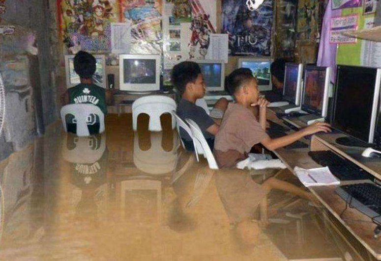 Kids Using Their Computers-In 2012 after serious flooding in the Philippines these photos circulated of kids playing on the computer. As many people pointed out, the reflections dont add up.