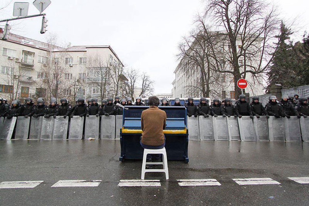 Man playing piano for police. Kiev, Ukraine, 2013