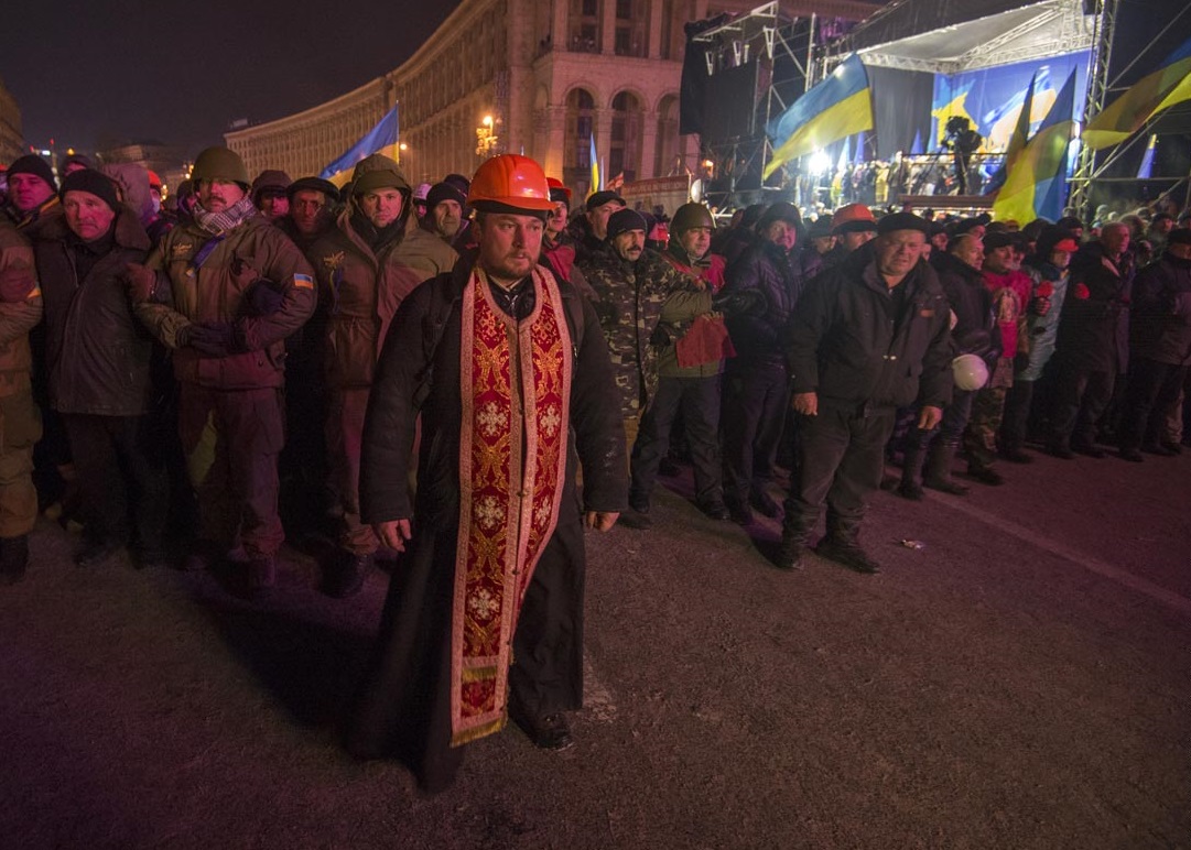 A brave priest organizes a human shield between protestors and police. Kiev, Ukraine, 2013