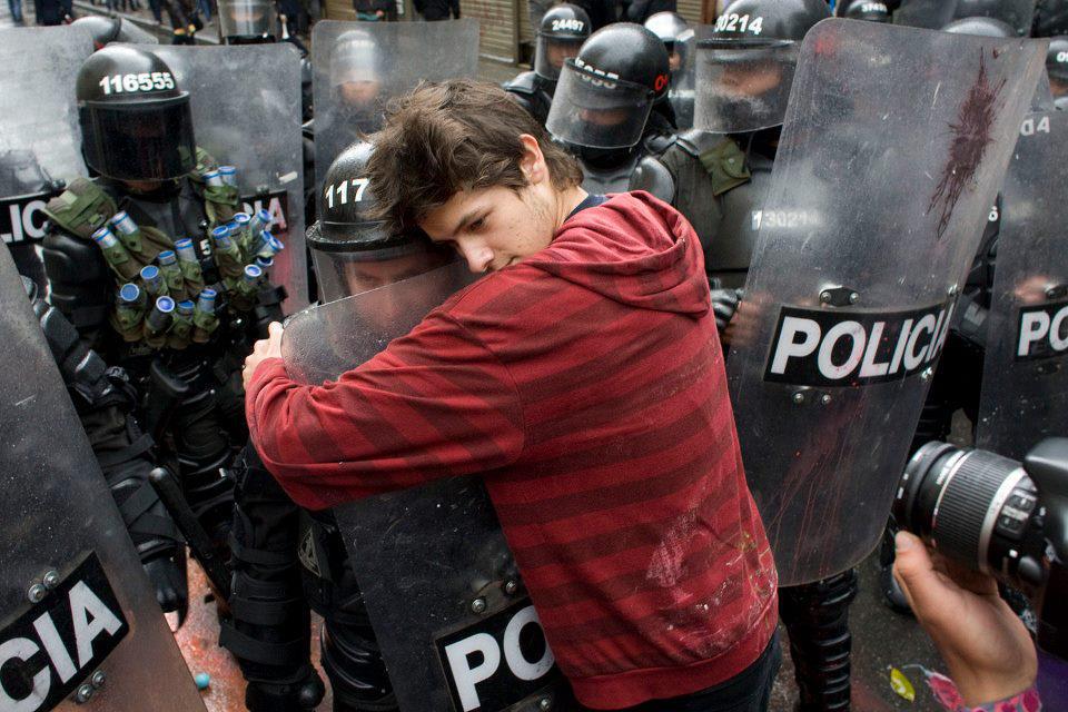 A student protesting education reform hugs a policeman. Bogota, Colombia, 2011
