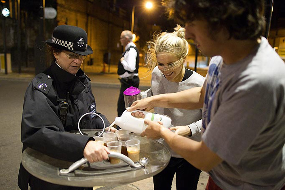 Caring citizens offer tea to British riot police. London, England, 2011