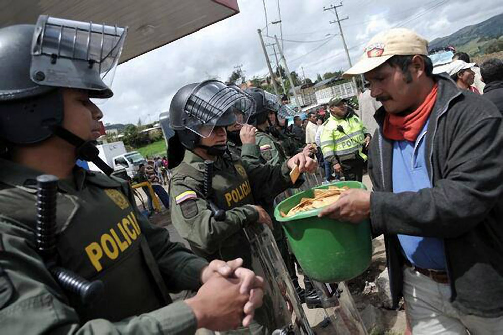 Protesters share crackers with Colombian riot police. Columbia, 2013