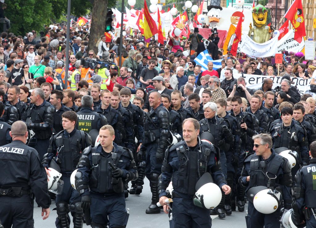 German riot officers take off their helmets and escort Occupy protesters. Frankfurt, Germany, 2011