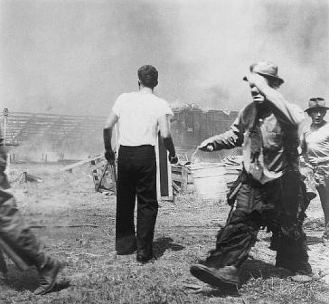 Sad clown Emmett Kelly, in his performer's makeup, carrying a bucket of water in the aftermath of the Hartford circus fire of July 6, 1944, in which at least 167 people were killed. The tragedy is often called "the day the clown cried" due to this photo