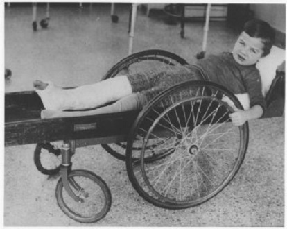 Boy in rolling "invalid cart" c. 1915