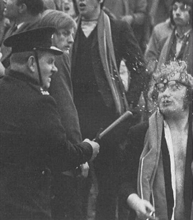 Gardai officer smashes glasses off someones face as the police charge crowds after a game between Cork Hibernians and Linfield from Belfast