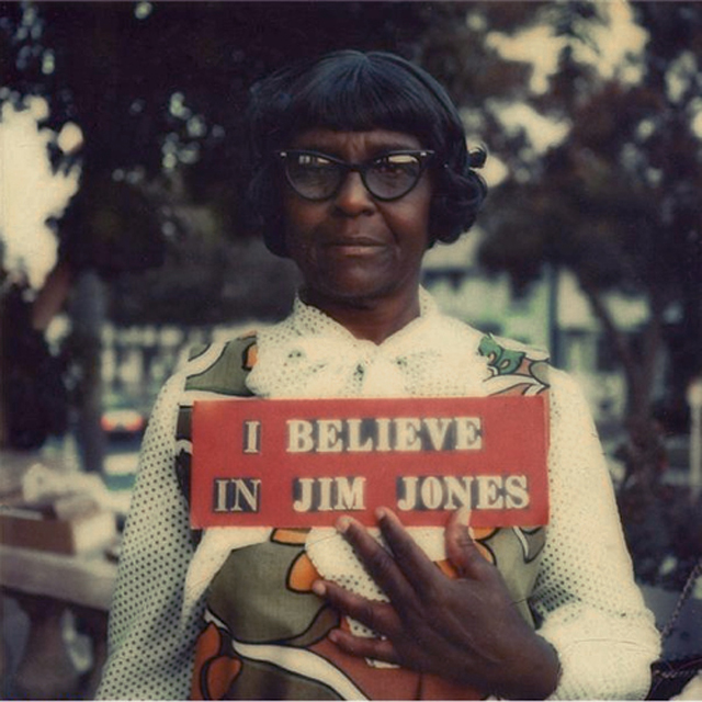 People's temple member holding a sign showing her support for cult leader Jim Jones, 1978