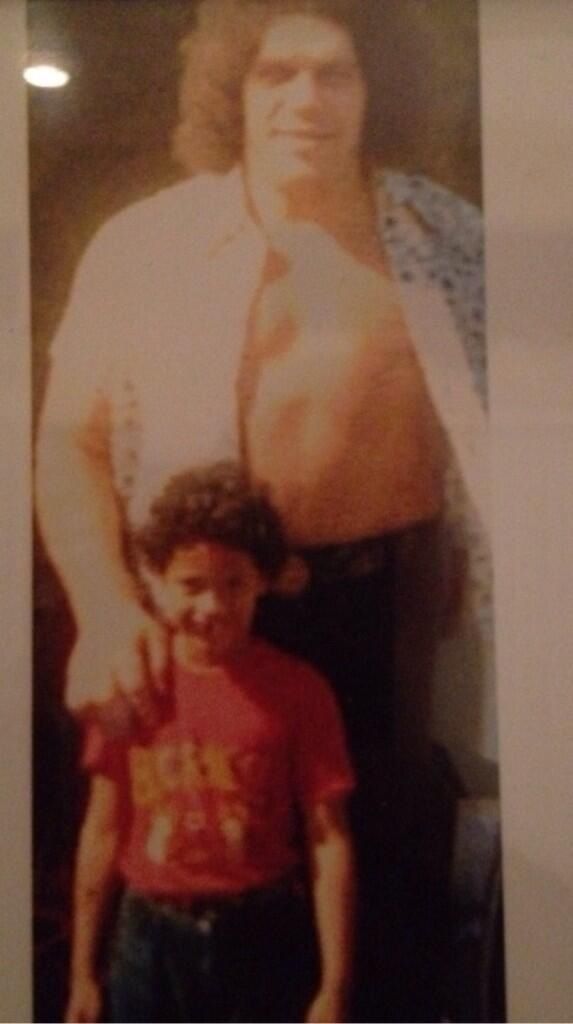 The Rock at age 5 posing with Andre the Giant