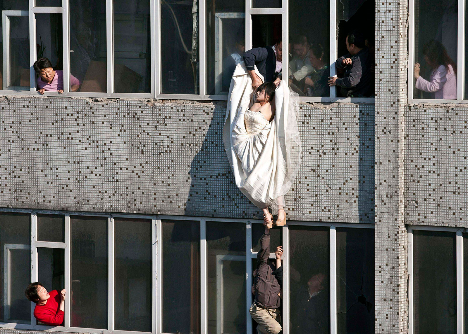A distressed bride attempts suicide in China after her fiance abruptly called off their marriage. Still in her wedding gown, she tried to kill herself by jumping out of a window of a seventh floor building. Right as she jumped, a man managed to catch and save her.