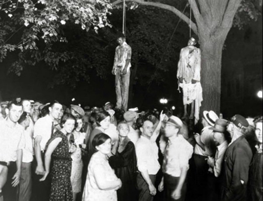 Taken by Lawrence Beitler during 1930. This hanging of two black men was due to a lie that they raped a white girl. This Photograph was used to show the Diplomacy of Whites during that age.