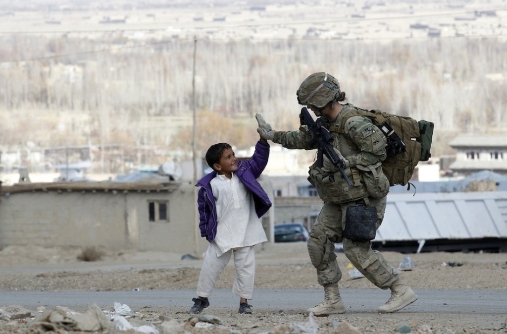 A U.S. Army soldier takes five with an Afghan boy during a patrol in Pul-e Alam, a town in Logar province, eastern Afghanistan.