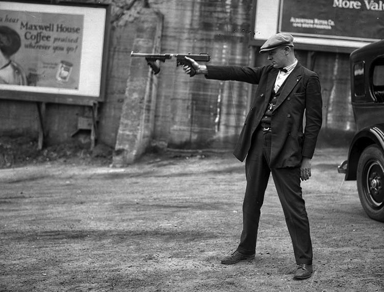 Lt. Oscar Bayer of the LAPD Detective Bureau aims a Thompson with a removed stock and no magazine for demonstration purposes. Pre-dating the Dillinger gang by six years this photo conveys the means by which bank robbers modified the Thompson to aid mobility and concealment 1927