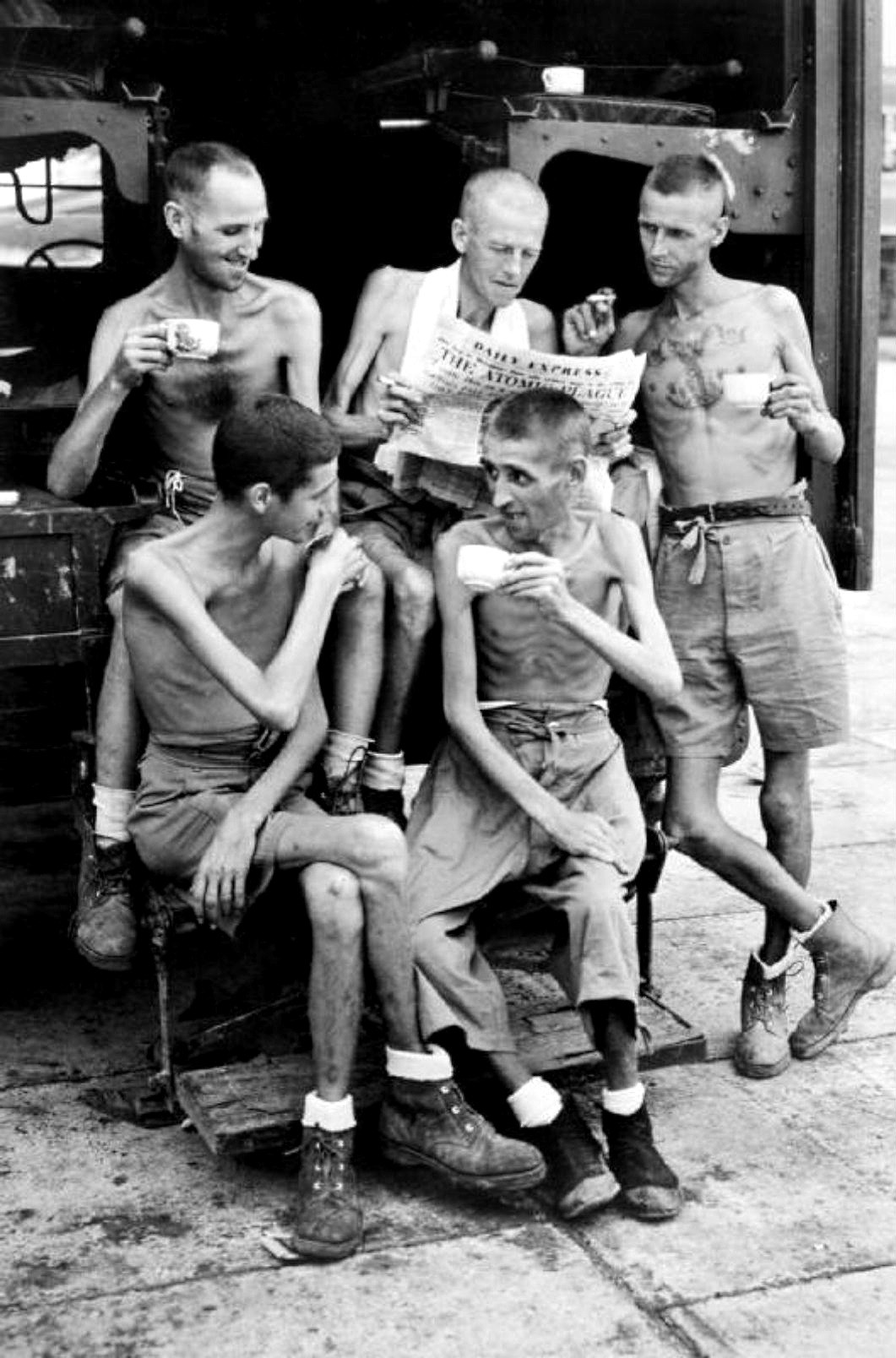 Five Australian former POWs catch up on news about the atomic bombings, after their release from Japanese captivity in Singapore, Sep 1945