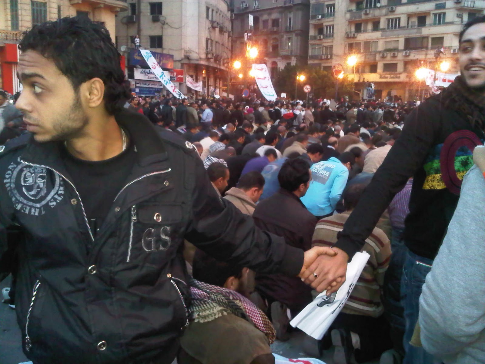 Christians protect Muslims in prayer at Tahrir Square during the Egyptian Revolution. 2011