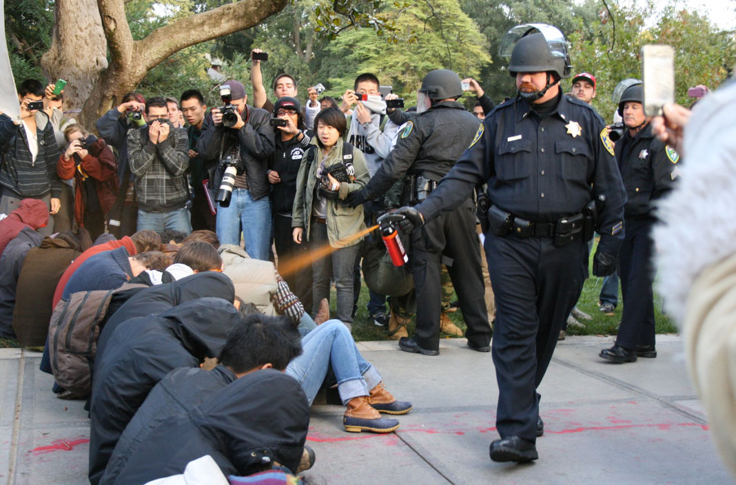 A police officer pepper-sprays Occupy protesters at the University of California. 2011