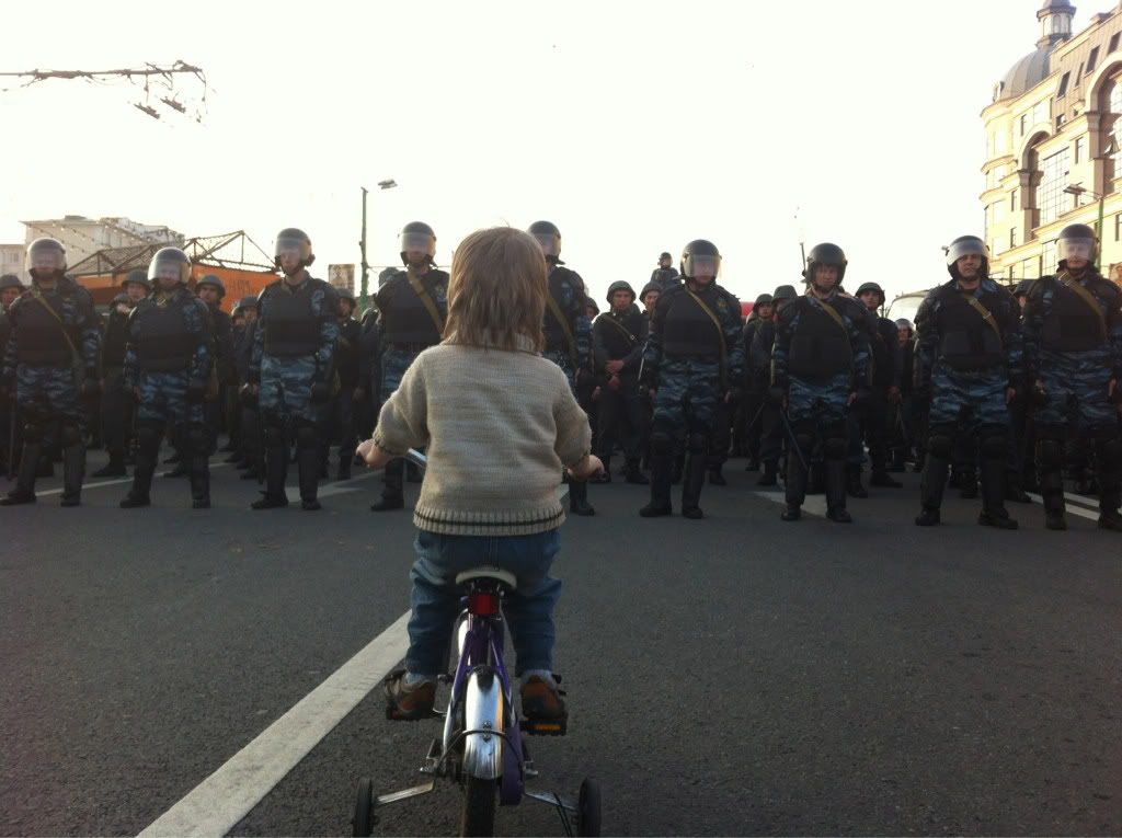 A boy on a bike faces off with Russian riot police during protests by Vladimir Putin's opposition. 2012