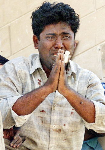 A Muslim man begging for his life during the Gujarat, India riots on March 1, 2002.