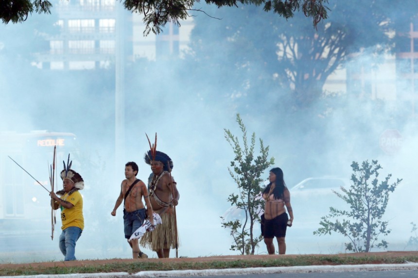 Indigenous people in Brazil shooting arrows at the police to protest against the worldcup