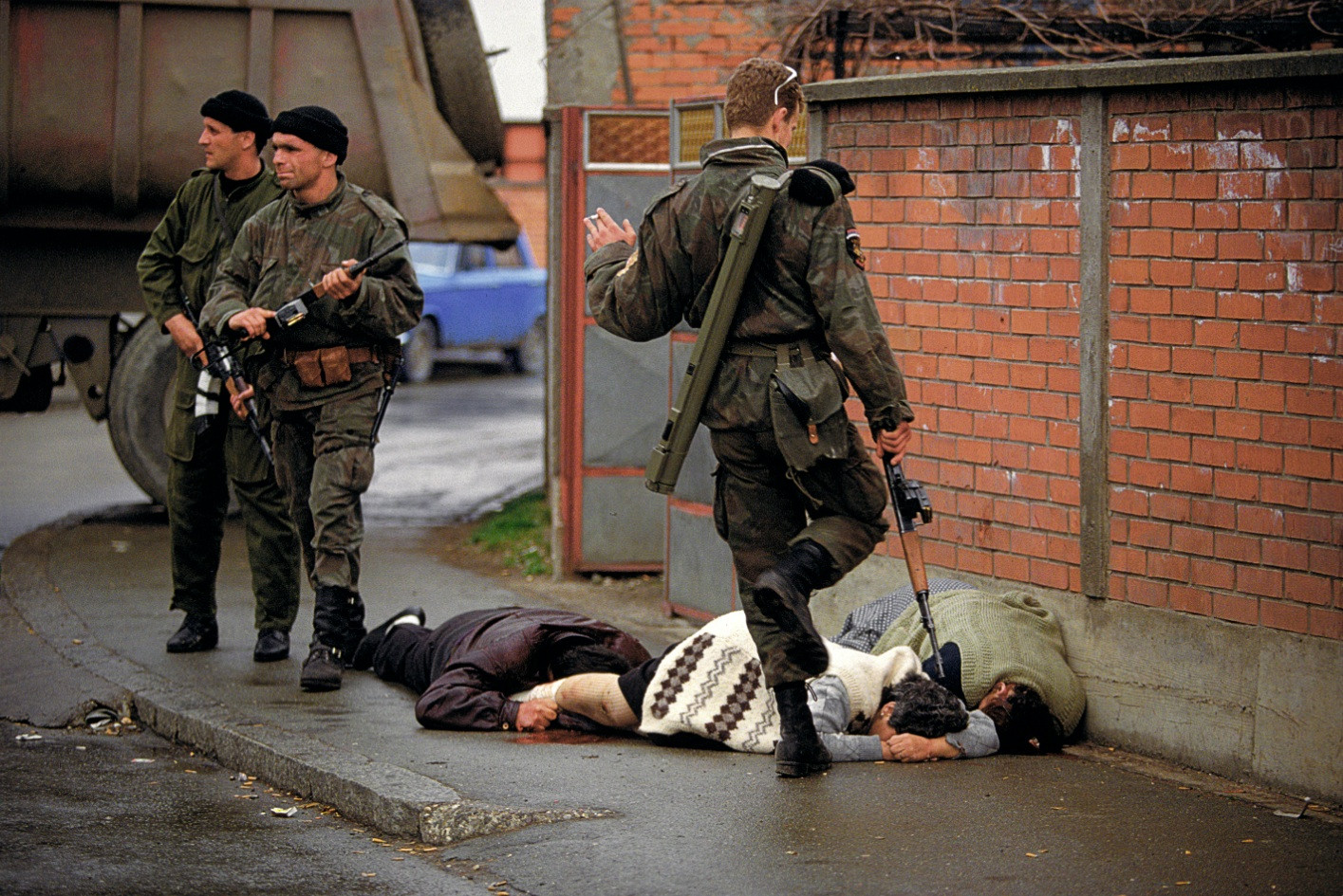 A member of the Serb Volunteer Guard, "SDG" kicks a dying Bosniak woman during the Bijeljina massacre of 1992