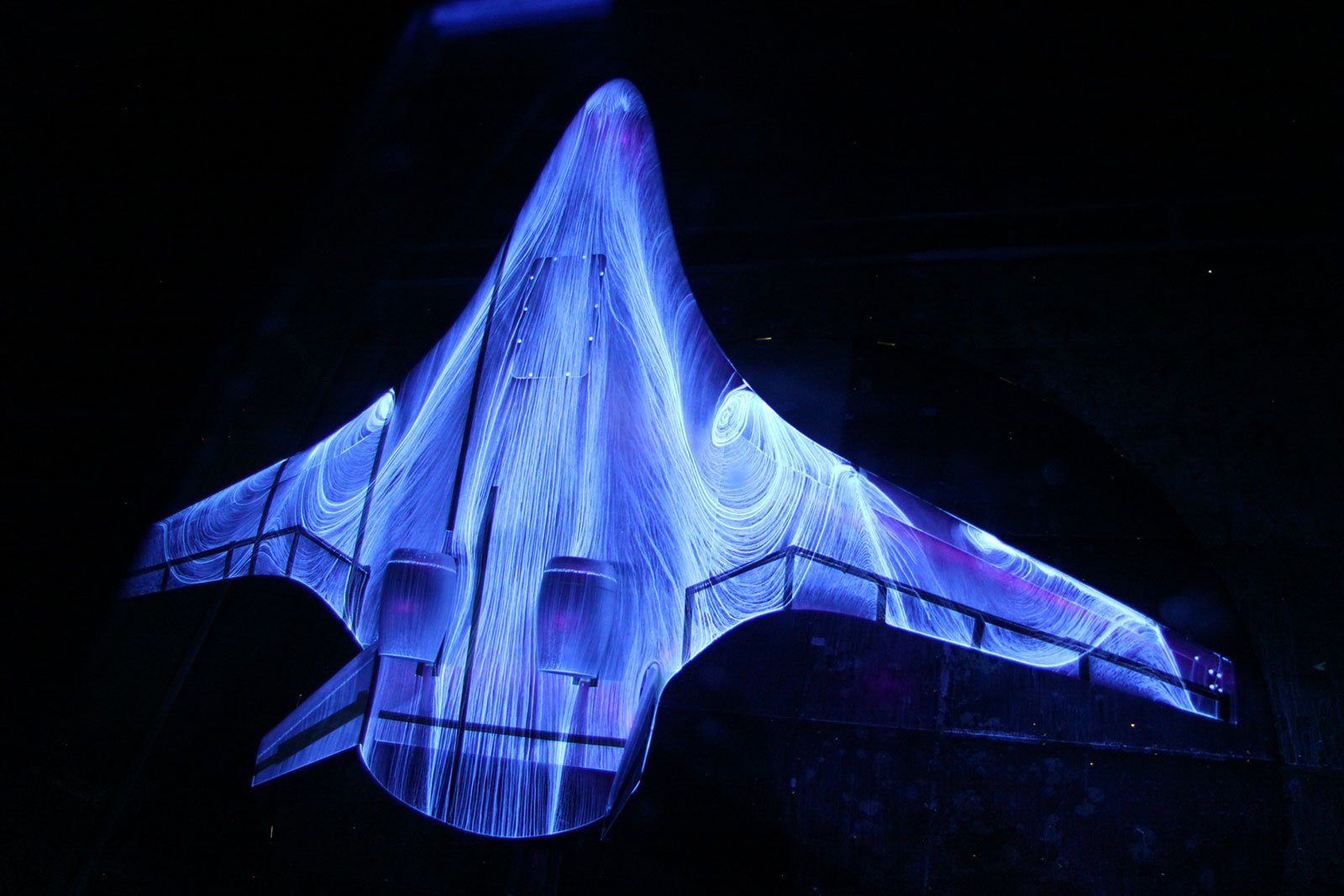 A futuristic hybrid wing body during tests in the wind tunnel at NASA's Langley Research Center. The patterns are formed by air movement over the fluorescent oil sprayed onto the wings