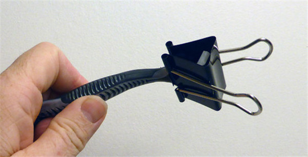 Use a binder clip to protect the head of shaving razors.