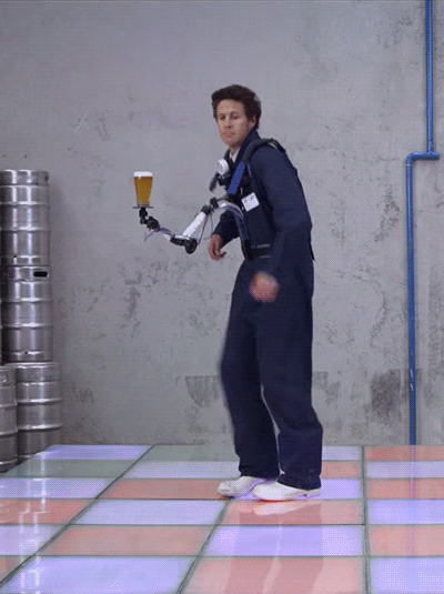 A guy using a robotic arm to boogie without spilling beer.