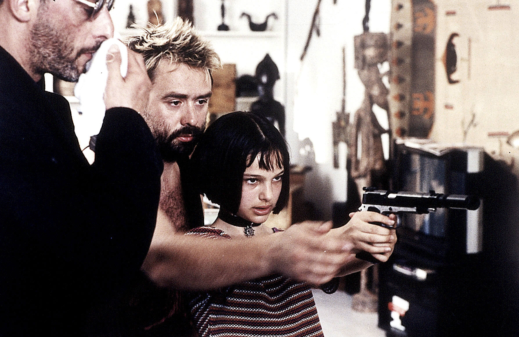 Luc Besson teaches twelve year-old Natalie Portman how to point a gun on the set of "Leon: The Professional"