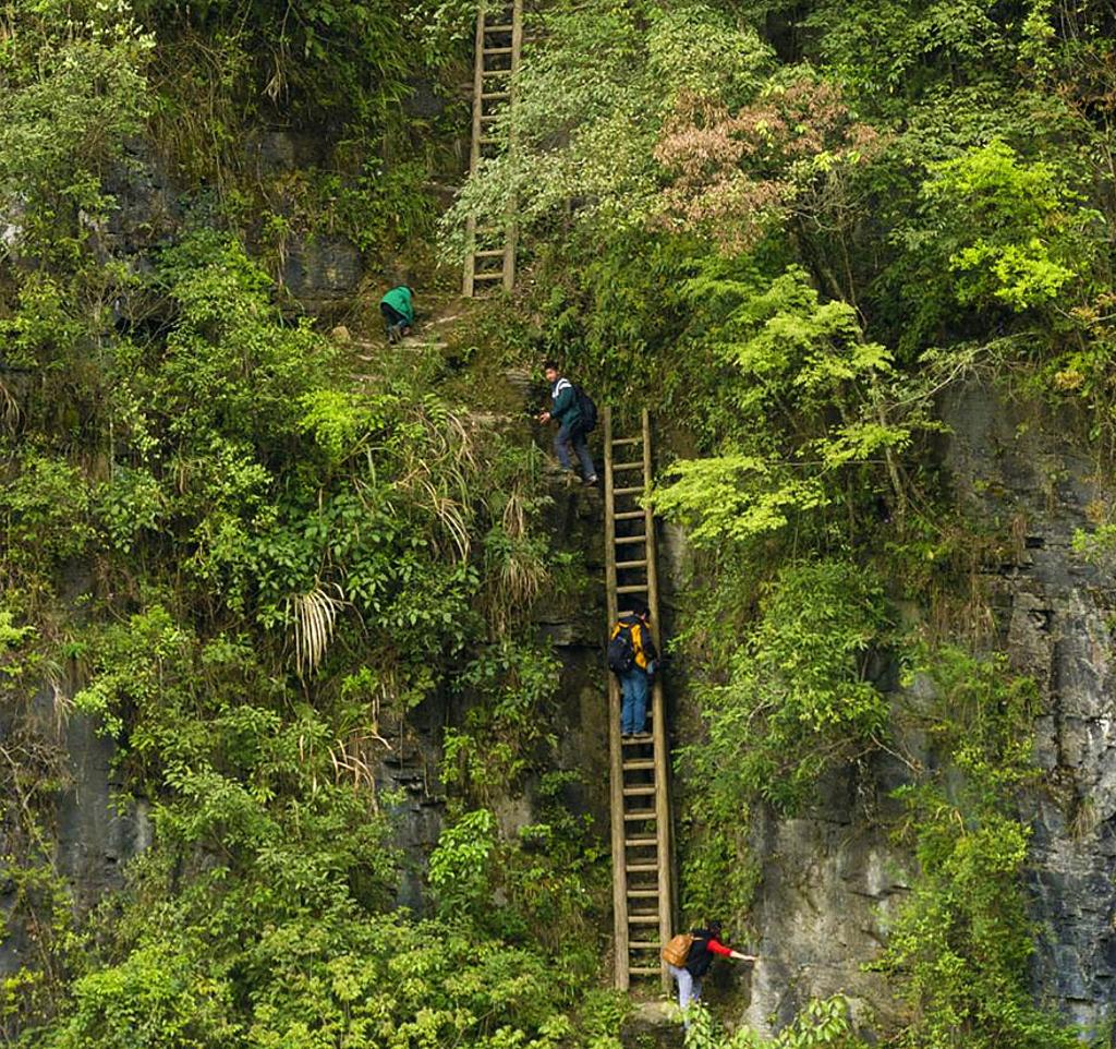 Schoolchildren climbing on unsecured wooden ladders in Zhang Jiawan Village, Southern China