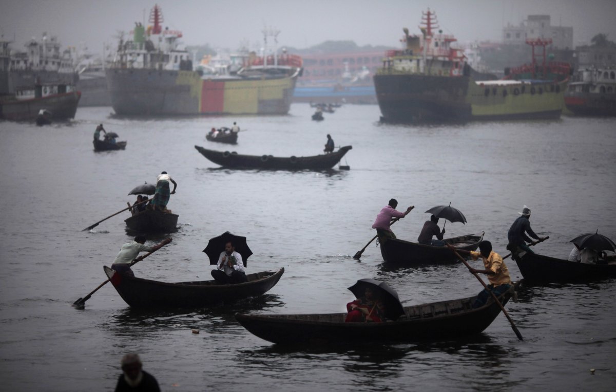 Thousands of people commute to work in Bangladesh by boat. Here, residents of Dhaka take out their umbrellas during shower.