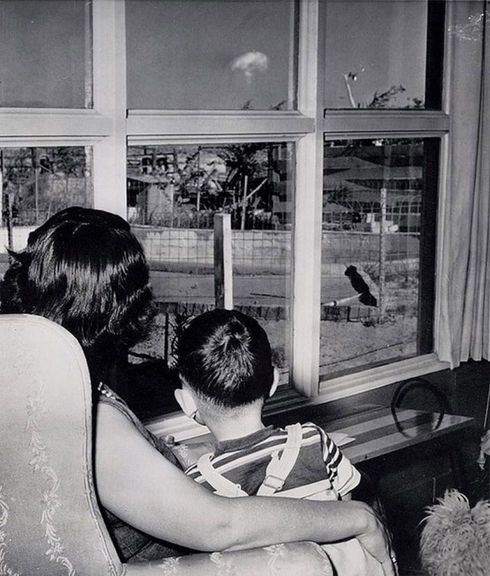 A  mom and her son watch the mushroom cloud after an atomic test 75 miles away in Las Vegas, 1953