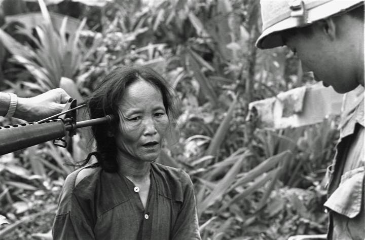 A female Viet Cong suspect is questioned at gunpoint by a South Vietnamese national police officer at Tam Ky, about 350 miles north of Saigon, November 1967