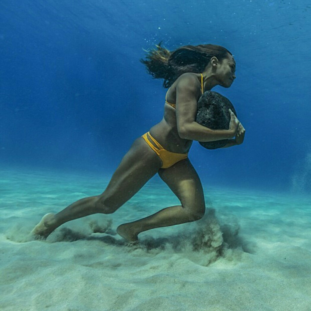 Hawaiian surfer Ha'a Keaulana runs across the ocean floor with a 50 pound boulder, as training to survive the massive surf waves.