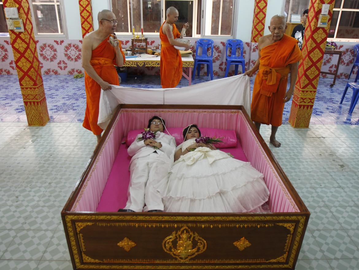 Groom Tanapatpurin Samangnitit, 40, and his bride, Sunantaluk Kongkoon, 26, lie in a coffin during a wedding ceremony at Wat Takien temple in the outskirts of Bangkok, Feb. 14. Couples believe laying briefly in the coffin will get rid of bad luck and usher happiness into their lives. This year, Valentine's Day fell on the same day as Makha Bucha Day, the day that honors Buddha.